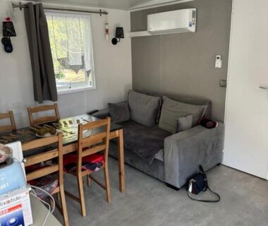 Intérieur du séjour avec canapé et coin repas du mobilhomme 3 Chambres avec piscine