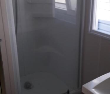 Salle d'eau avec cabine de douche et lavabo dans le camping omer port la nouvelle