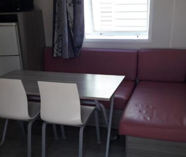 Séjour avec table chaises et banquette dans le camping Omer Port la Nouvelle
