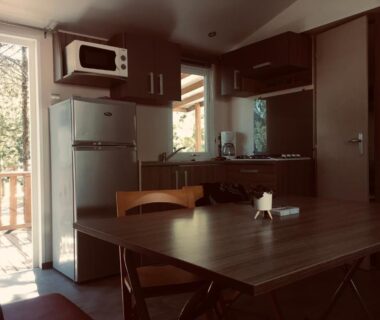 Intérieur avec kitchenette table et terrasse du parc des 7 fonts