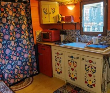 Intérieur avec kitchenette coin évier meuble peint et matelas dans la roulotte Tipergwendiou