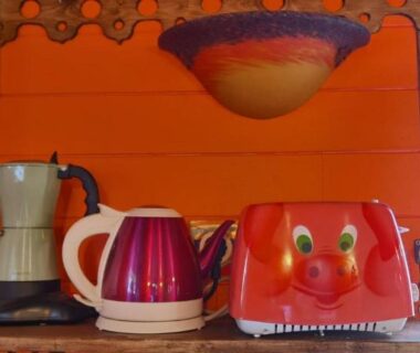 Intérieur coin cuisine avec grille-pain rouge bouilloire et cafetière dans la roulotte Tipergwendiou