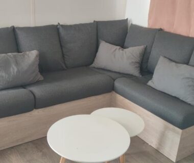 Coin salon avec canapé d'angle et tables basses dans le logement sable du midi 1