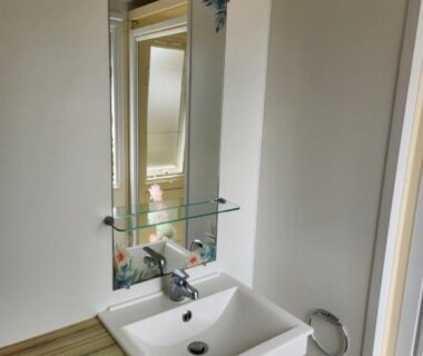 Salle de bain avec lavabo miroir et étagère en verre dans l'hébergement Sol a gogo 3 ch
