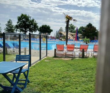 Bord de la piscine avec transats et pelouse au Sweet mobil-home