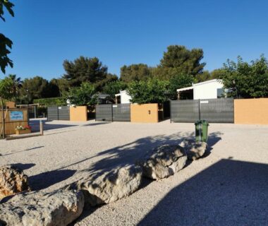 Emplacement gravillonné avec mobil-homes et murets au camping tony vacances