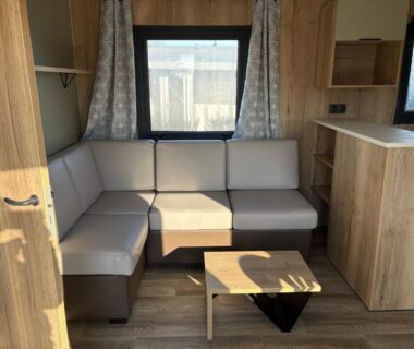 Coin salon avec banquette et table dans le mobil-home zoubidou